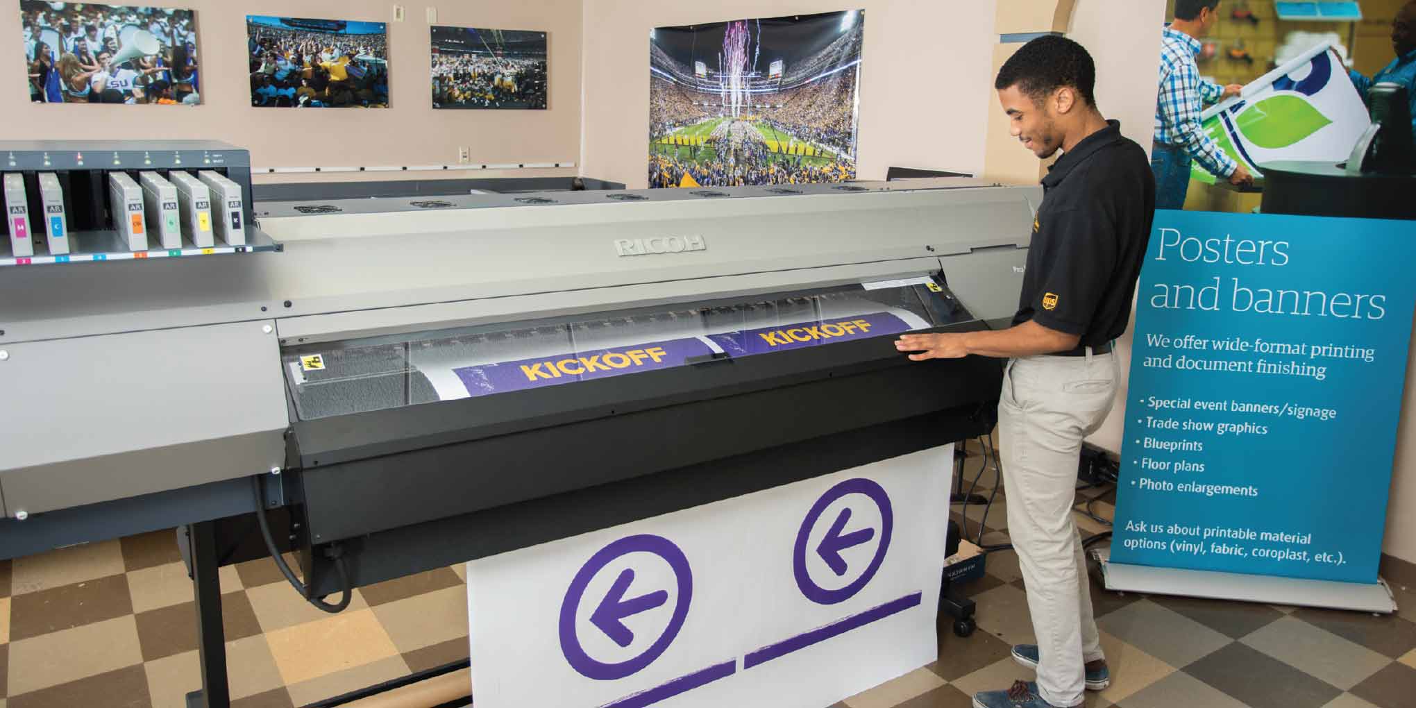 A The UPS Store employee printing a large banner