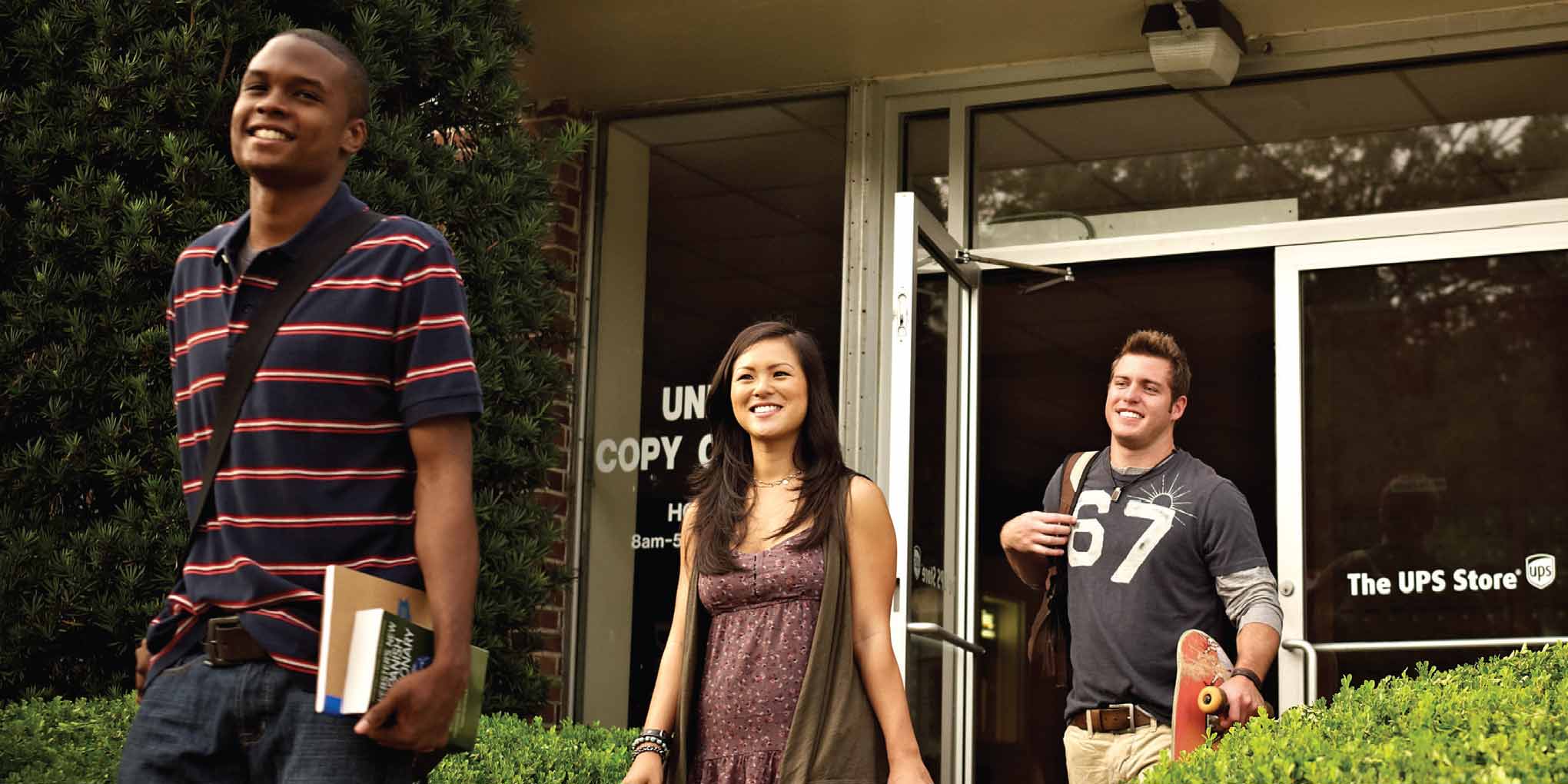 Three students walking out of a campus The UPS Store