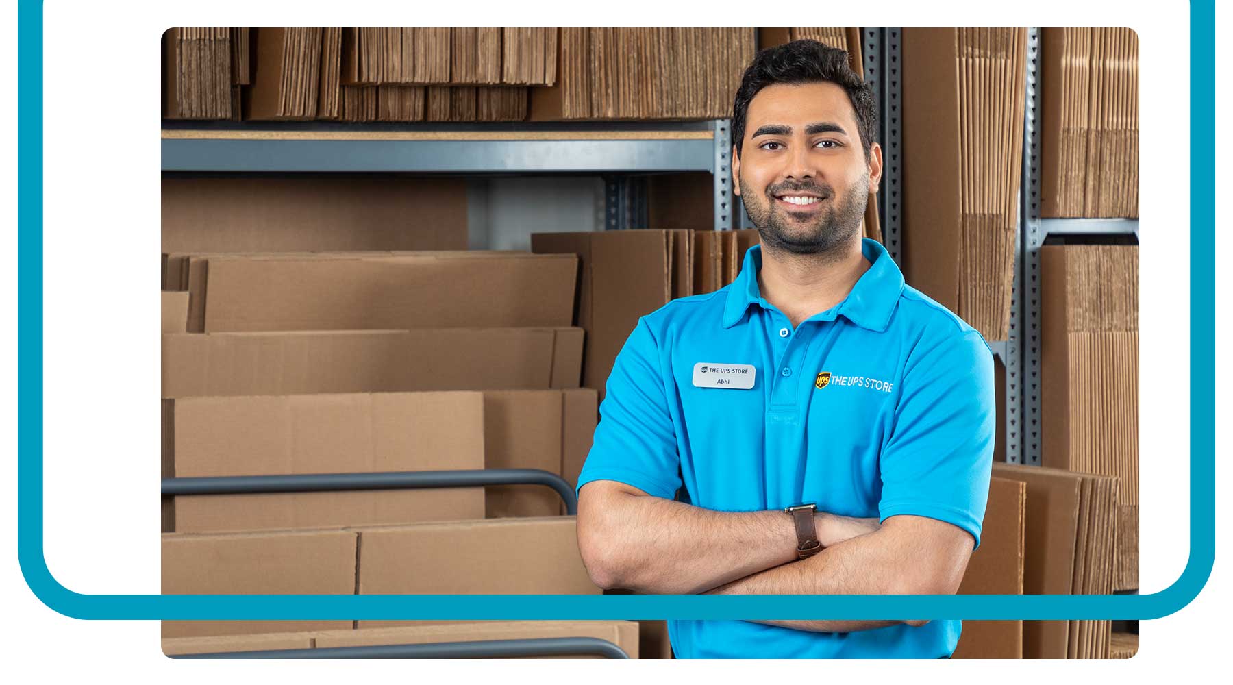 A franchisee standing in a The UPS Store smiling in front of boxes